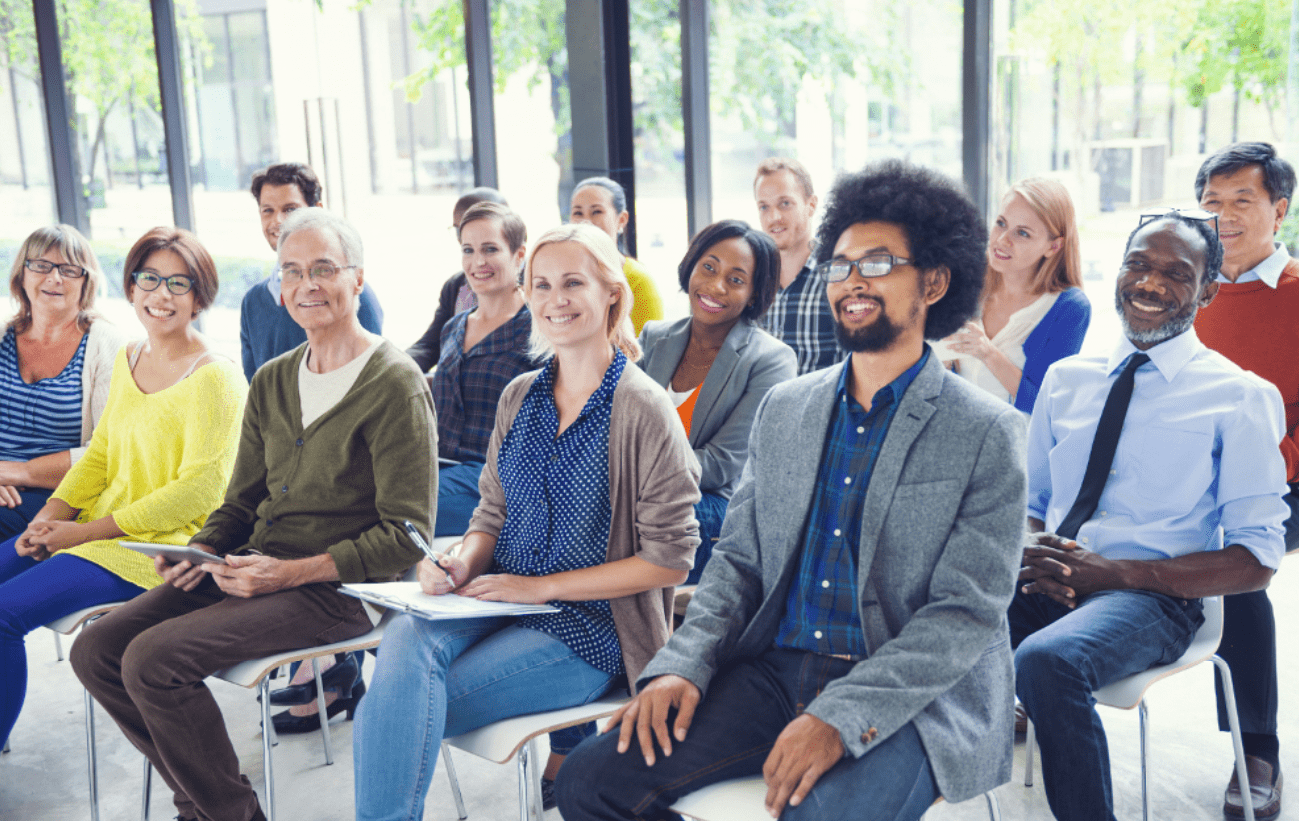 Menschen, die mit Laptop an einem Tisch sitzen