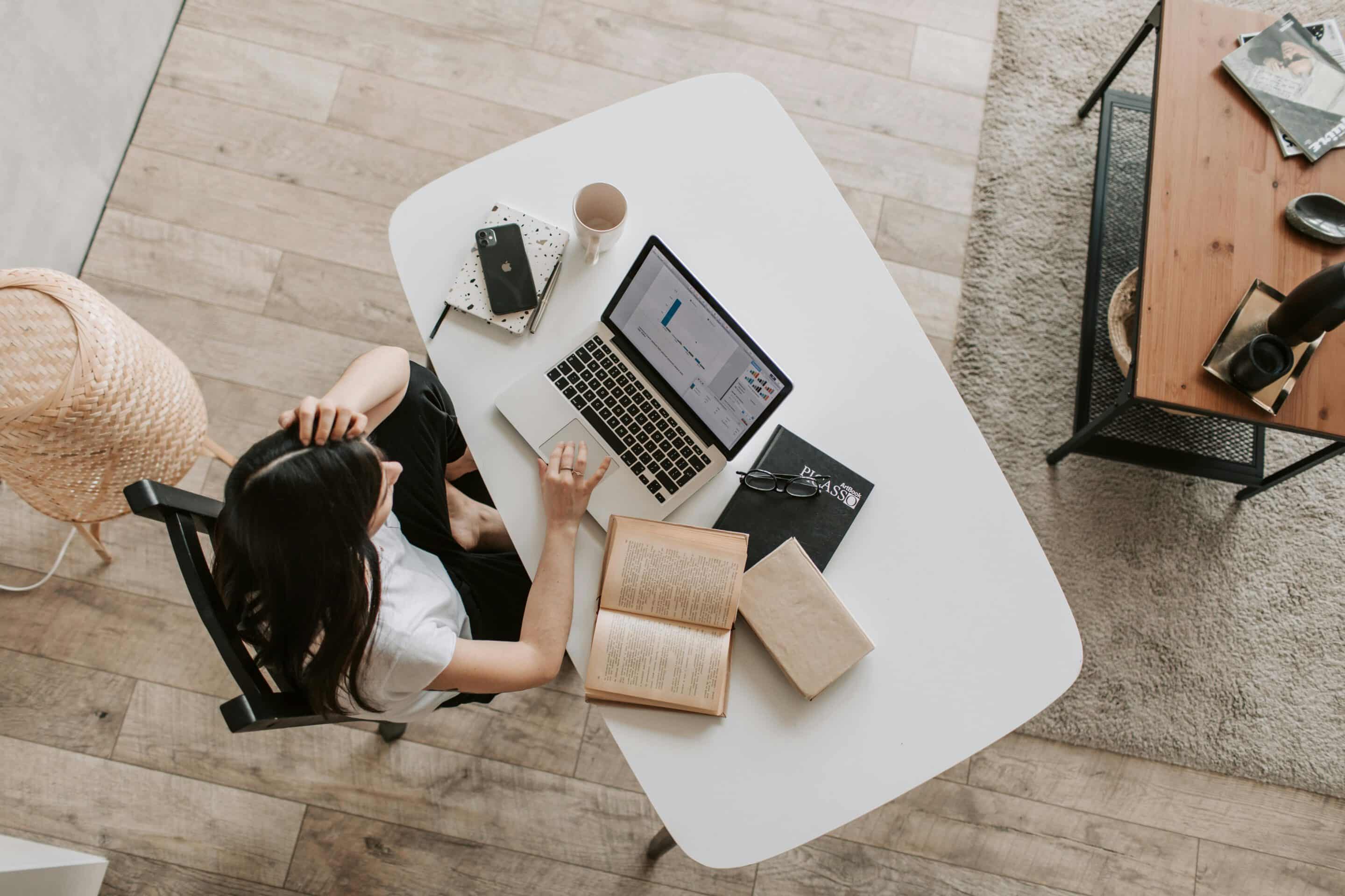 Homeoffice Eine Frau sitzt am Tisch und arbeitet