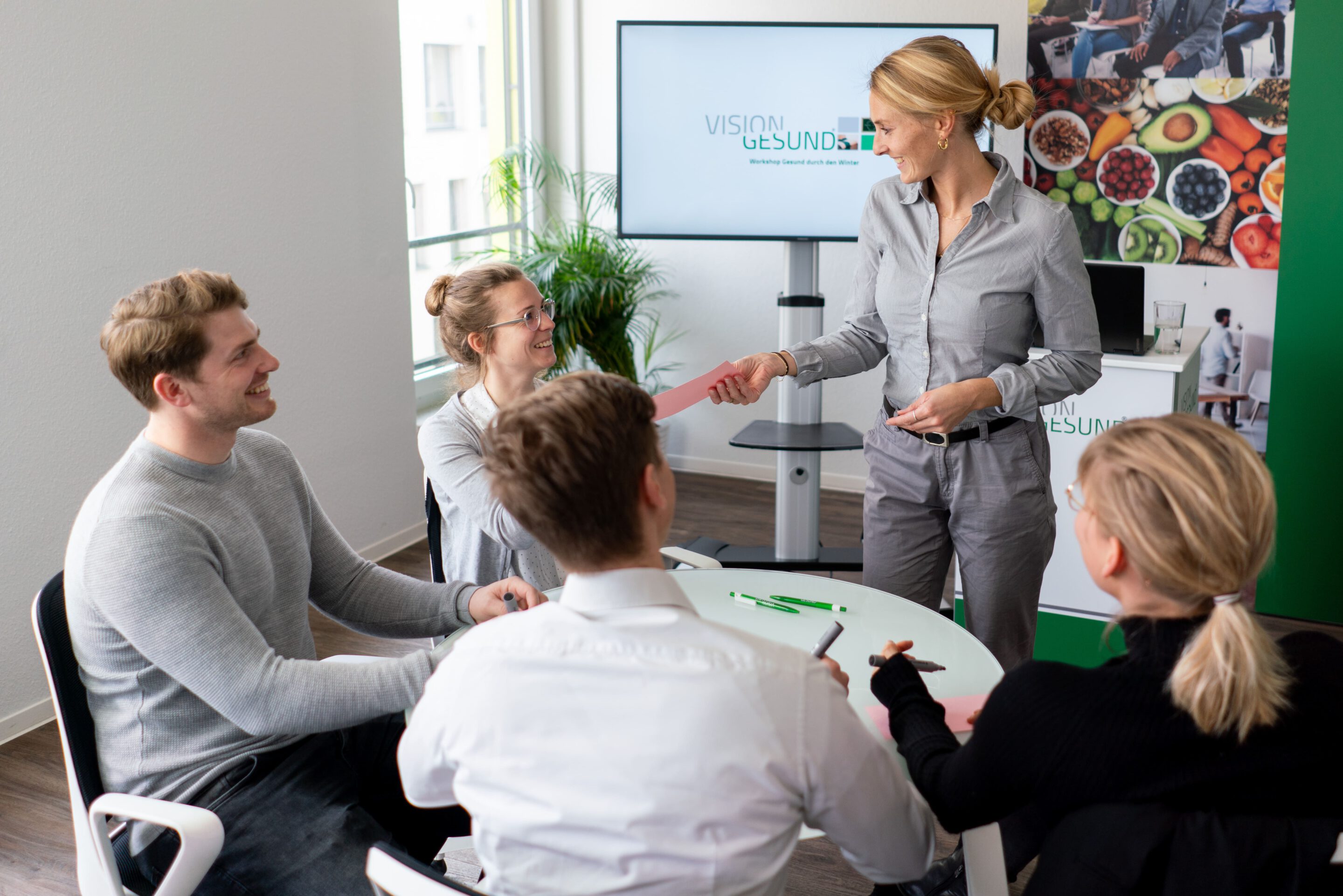 Eine Abeitsgruppe sitzt zum Strategie-Workshop GB Psyche zusammen an einem runden Tisch.