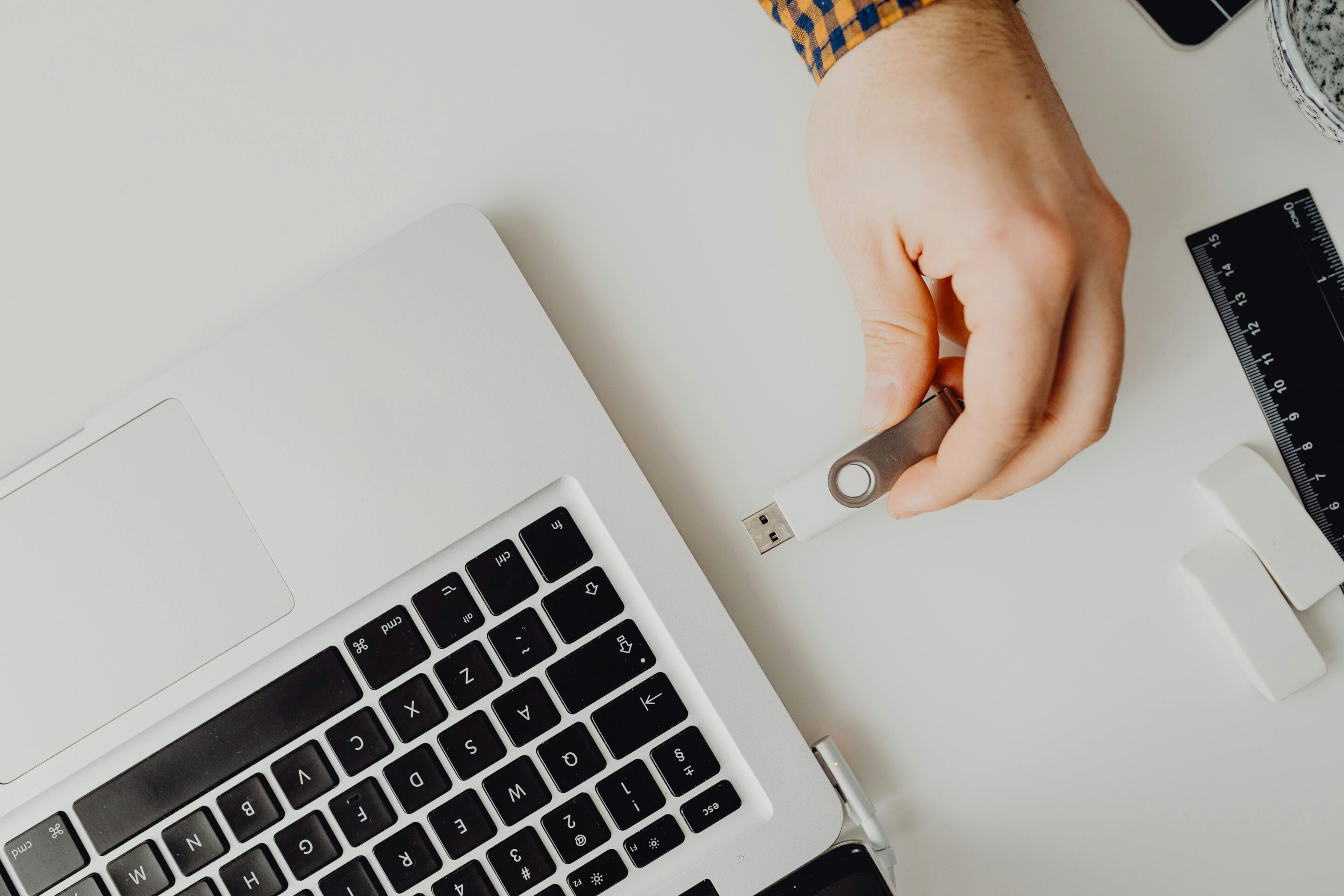 Ein USB Stick wird in einen Laptop eingesteckt