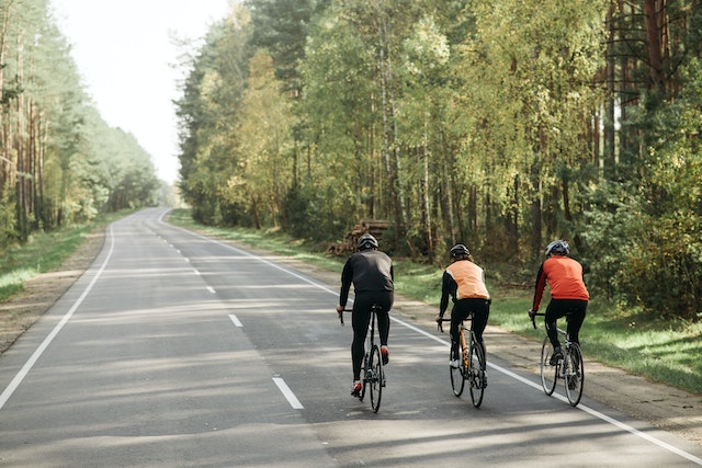 Drei personen in Bewegung beim Radfahren aus der Straße